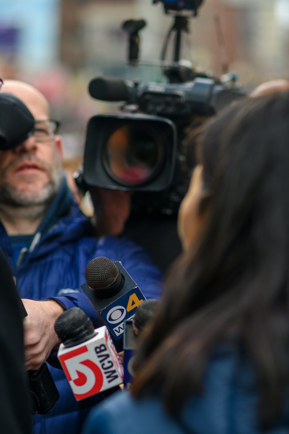 Periodistas con micrófonos entrevistan a alguien fuera de cámara.